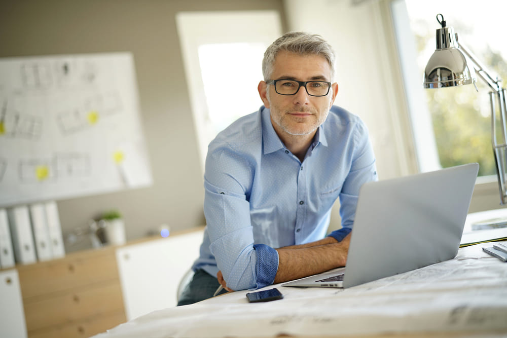 Architect looking at the camera in his office