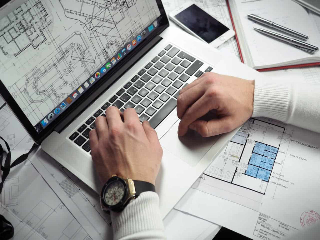 Man creating a 3D site plan rendering on a laptop